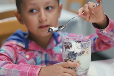 Close-up of boy eating ice cream while sitting at home