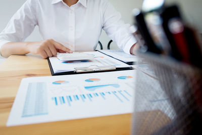 Midsection of man using laptop on table