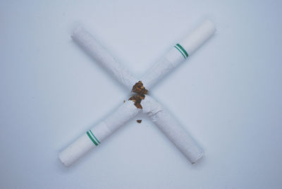 High angle view of cigarette on table against white background