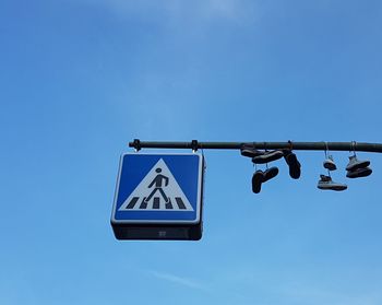 Low angle view of road sign against blue sky