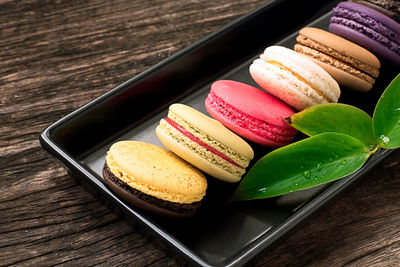 Colorful and delicious french macaron cookies varieties on a wooden table