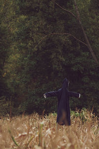 Scarecrow on field in forest