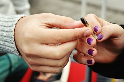 Cropped hand sharing cigarette