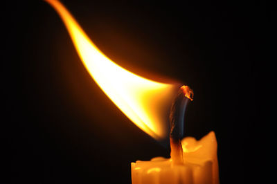 Close-up of lit candle at night