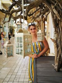 Portrait of smiling young woman standing against building