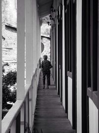 Full length rear view of woman walking in tunnel