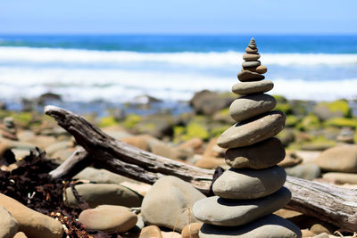 Stack of stones on beach against sky