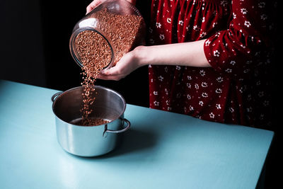 Midsection of woman pouring coffee in cup