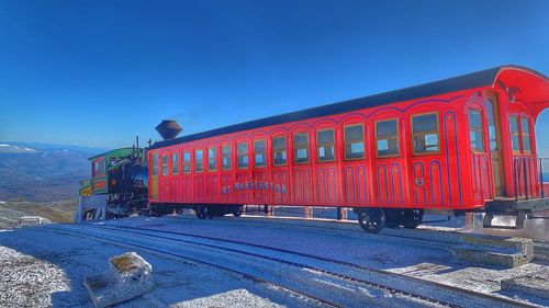 Train on railroad track against blue sky