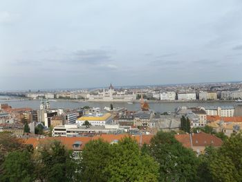 Buildings in city against cloudy sky