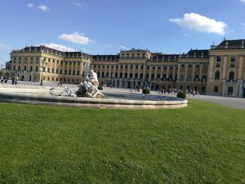 Statue fountain by schonbrunn palace against sky