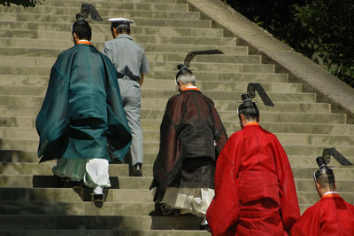 Few men climbing the stairs wearing traditional clothes