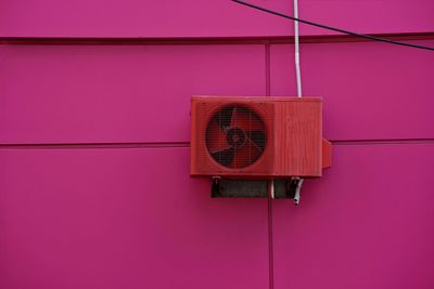 Air conditioner compressor on pink wall