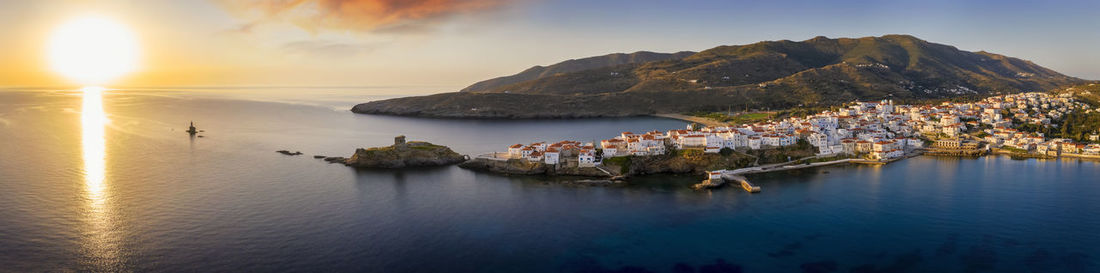 Panoramic view of sea and buildings against sky during sunset