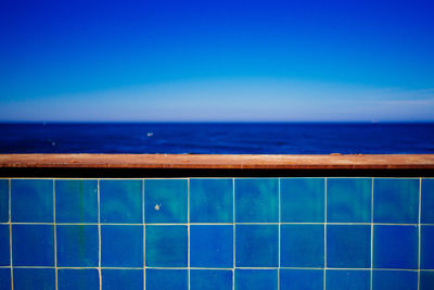 Blue tiled railing against sea