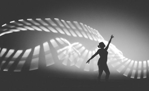 Full length of man standing by illuminated stage against clear sky