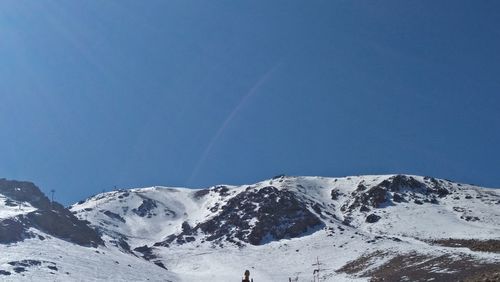 Scenic view of snowcapped mountains against clear blue sky