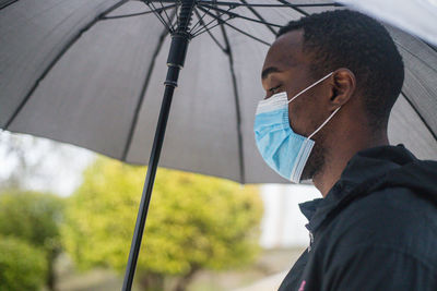 Portrait of young man in rain