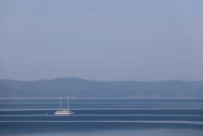 Sailboat in sea against clear sky