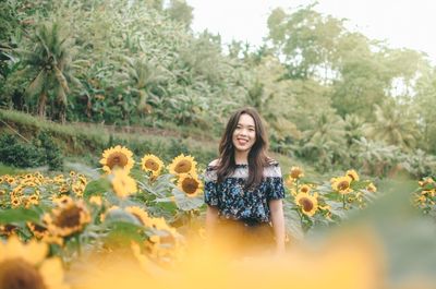 Portrait of smiling young woman with plants