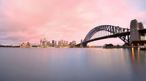 Sydney harbor bridge over parramatta river in city during sunset