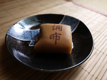 Close-up of cake in black plate on mat