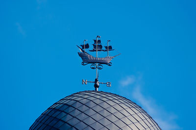 Low angle view of weather building against blue sky