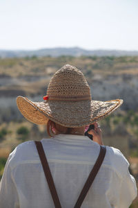 Girl traveler in a straw hat in the mountains travels in summer