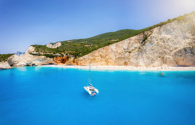 Sailboat in sea against blue sky