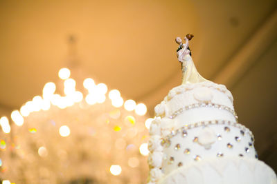 Close-up of figurine on illuminated cake