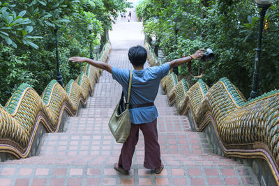 Rear view of man standing by staircase