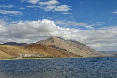 Scenic view of lake by mountains against sky