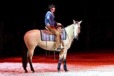 Side view of man riding horse