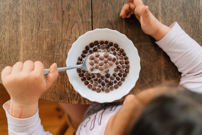 Hand of girl having breakfast at home