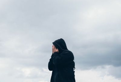 Full length of man standing in rain against sky