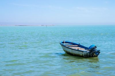 Boat moored on sea against sky