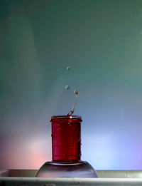 Close-up of water bottle on glass table with drops