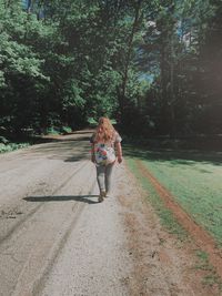 Rear view of woman walking on footpath