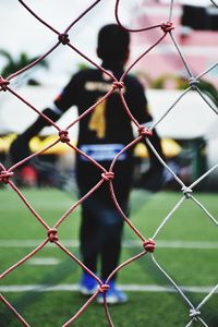 Soccer player seen through sports net