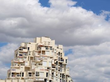 Low angle view of buildings against cloudy sky