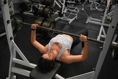 Muscular man lifting dumbbell in gym