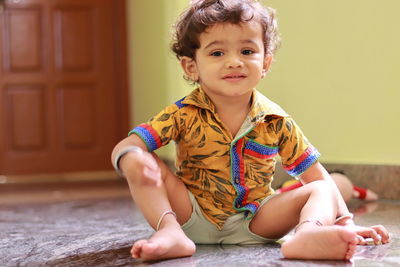 Portrait of cute smiling girl sitting on floor at home