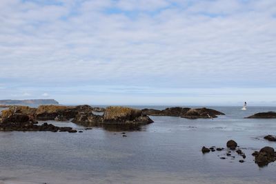 Rocks on beach against sky