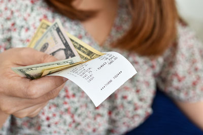 Midsection of woman holding paper with text