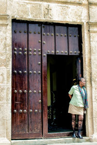 Rear view of man standing against old building