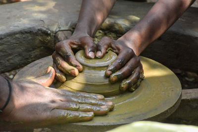 Low section of man making pottery at workshop