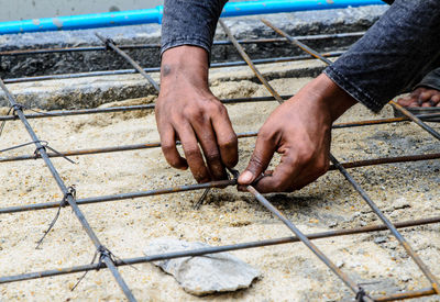 Cropped hands of man holding metal rod