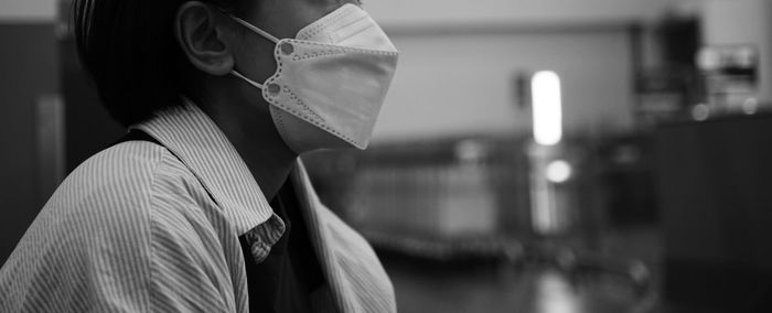 Side view of young woman standing in city