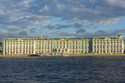 View of building by sea against cloudy sky