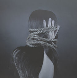 Woman with tied hair against gray background